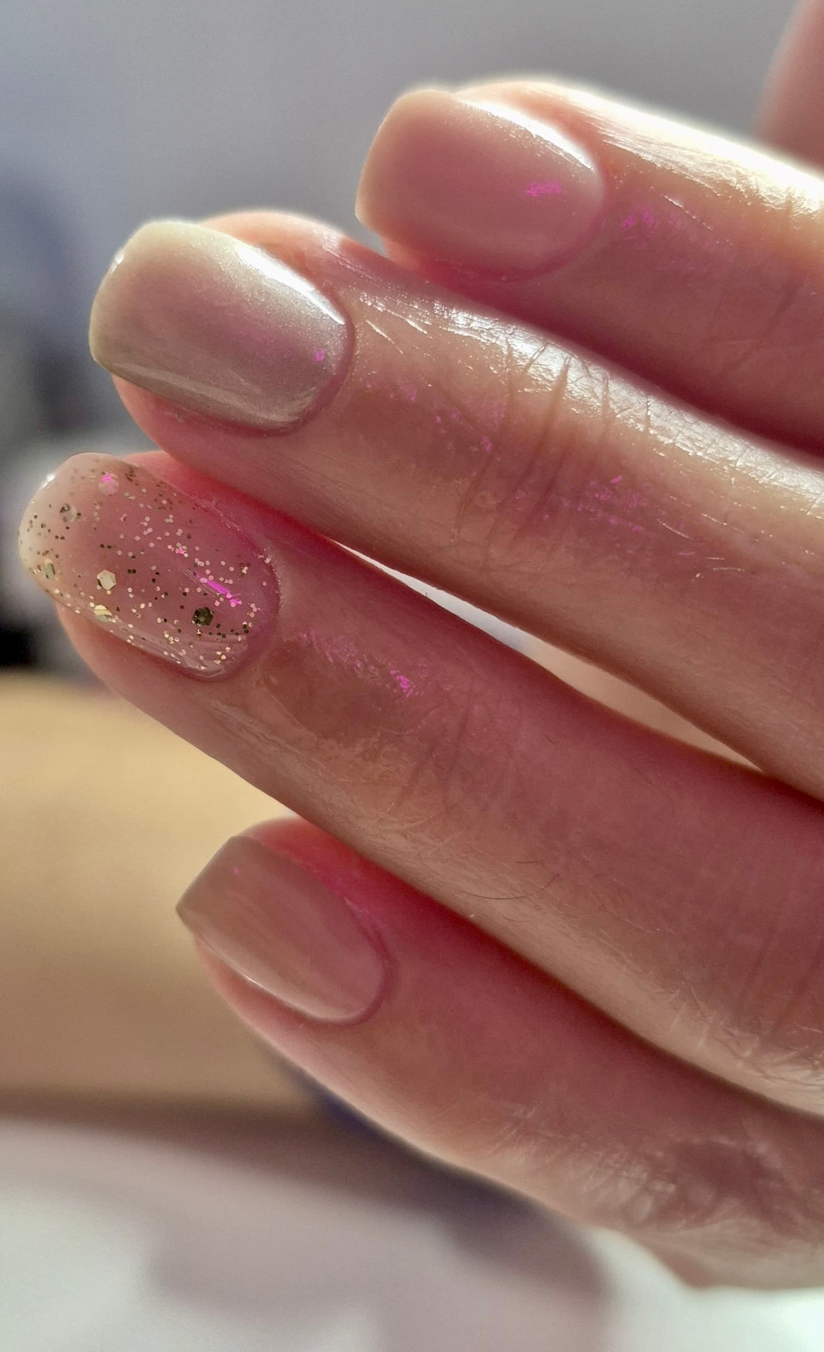 Manicura nude perlada con acento de glitter dorado
