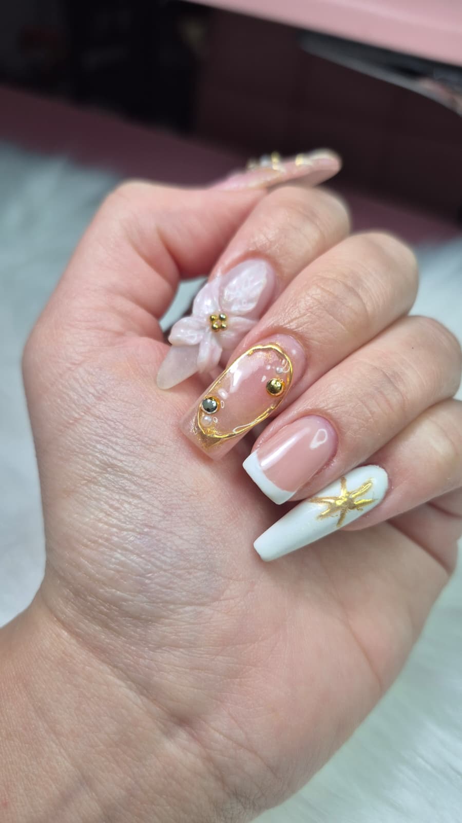 Manicura artística con flor 3D rosa, detalles dorados y francés blanco